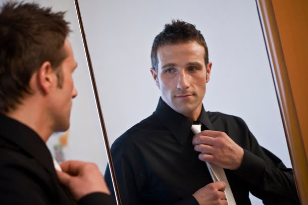 Man Checking Tie in Mirror